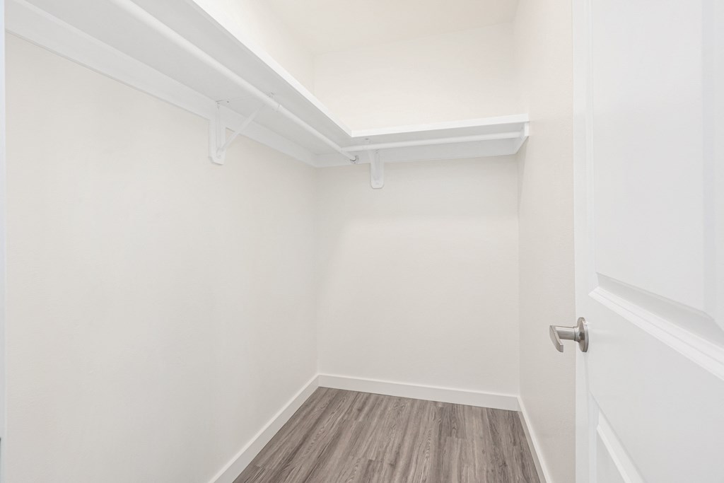 an empty room with white walls and a wooden floor