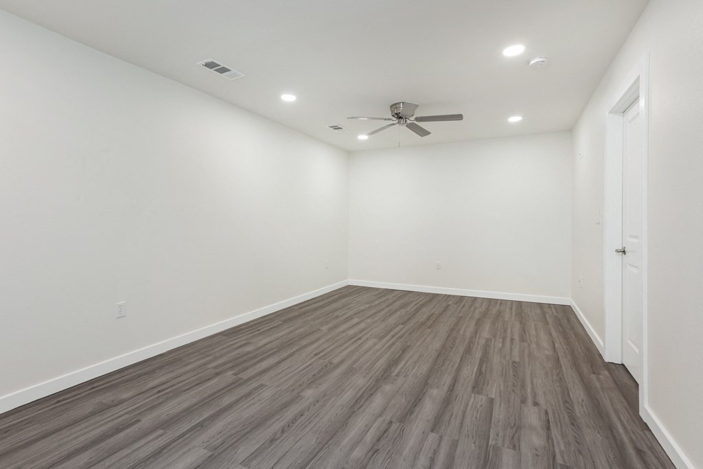 a bedroom with hardwood floors and white walls