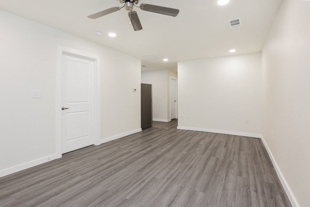 a bedroom with a ceiling fan and hardwood floors