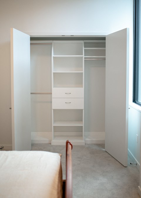 A white bedroom with a large wardrobe and a bed.