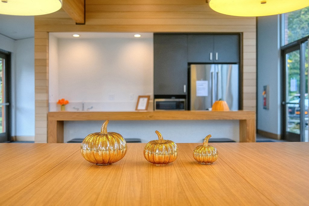three pumpkins sitting on a wooden table in front of a reception desk
