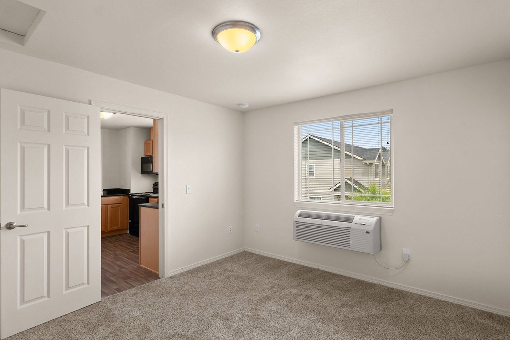 a living room with a window and a door to a kitchen at Trillium Apartments, Springfield, Oregon