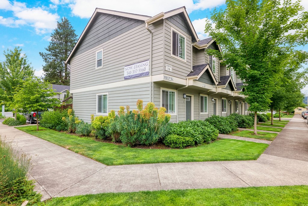 a house with a sidewalk in front of it and some trees a house with a sidewalk in front of it and some trees at Trillium Apartments, Springfield, OR