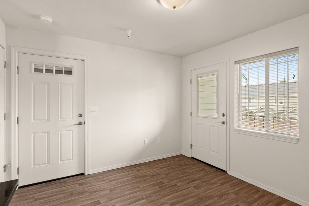the living room of an empty home with white walls and wood flooring at Trillium Apartments, Springfield, 97477