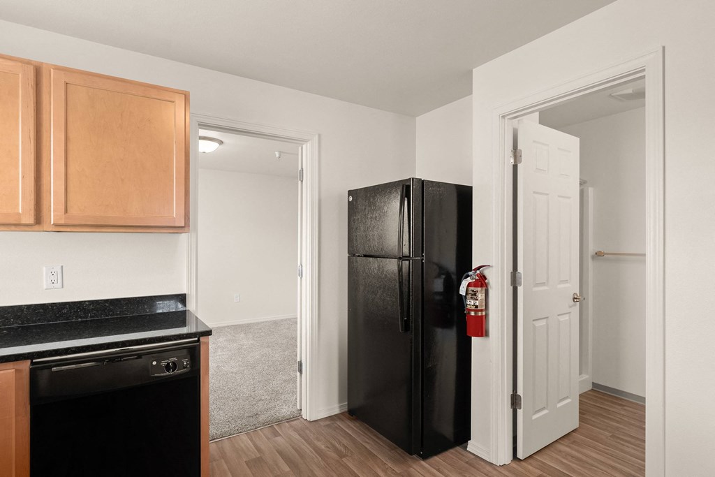 a kitchen with a black refrigerator and a door to a hallway at Trillium Apartments, Oregon 97477