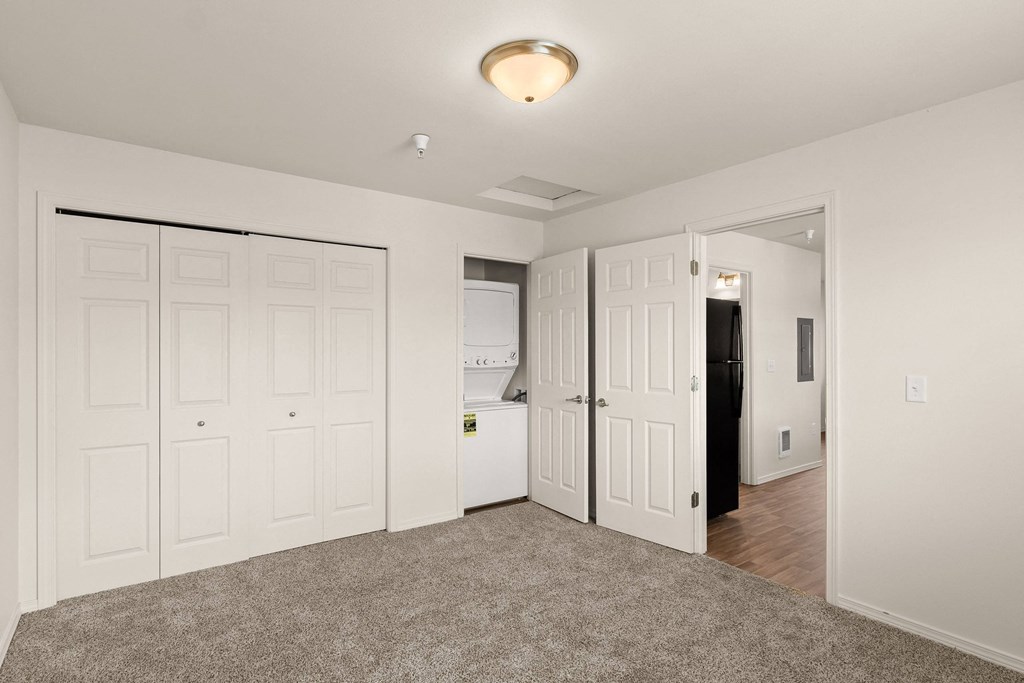 a bedroom with white closets and a door to the bathroom at Trillium Apartments, Springfield, OR, 97477