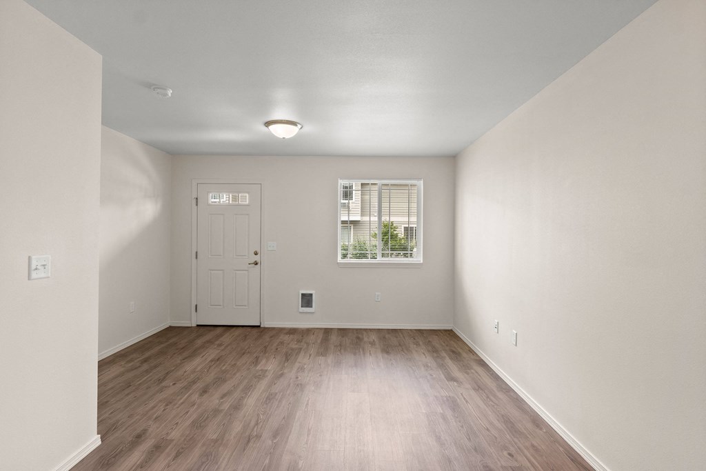 an empty living room with white walls and wood floors an empty living room with white walls and wood floors at Trillium Apartments, Springfield, Oregon