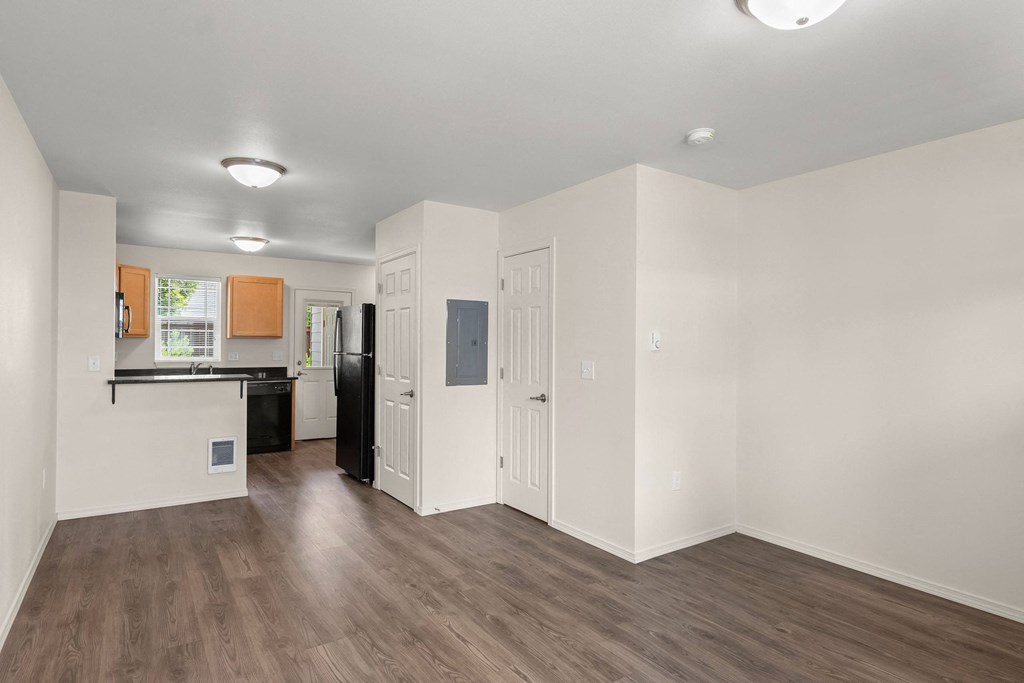 a renovated living room and kitchen with white walls and wood floors at Trillium Apartments, Springfield, 97477