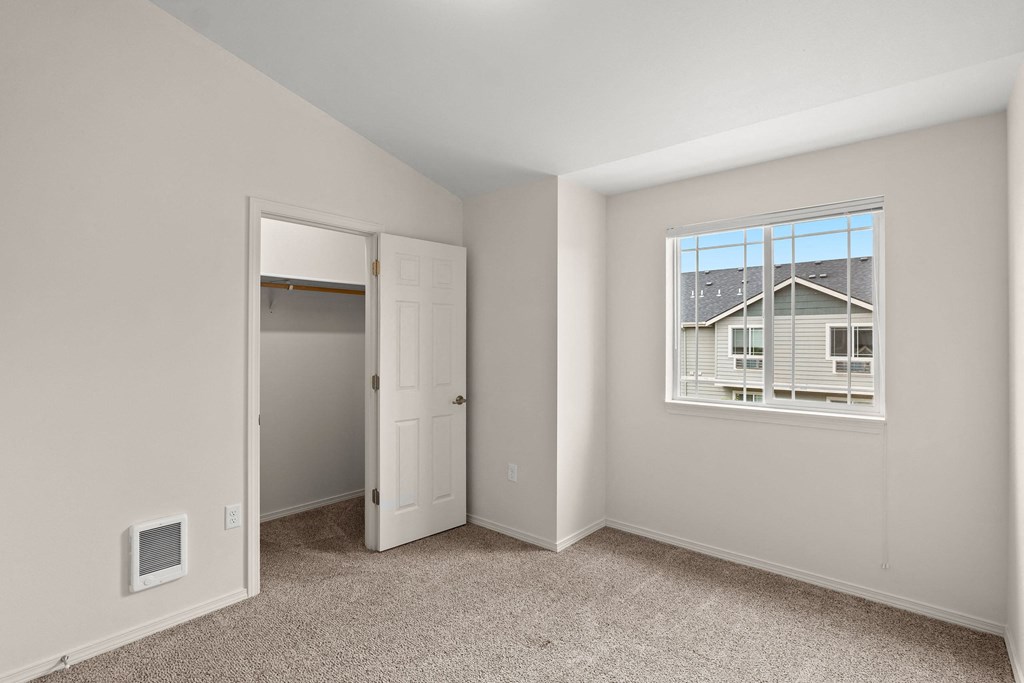 a bedroom with a window and a door to a closet at Trillium Apartments, Springfield