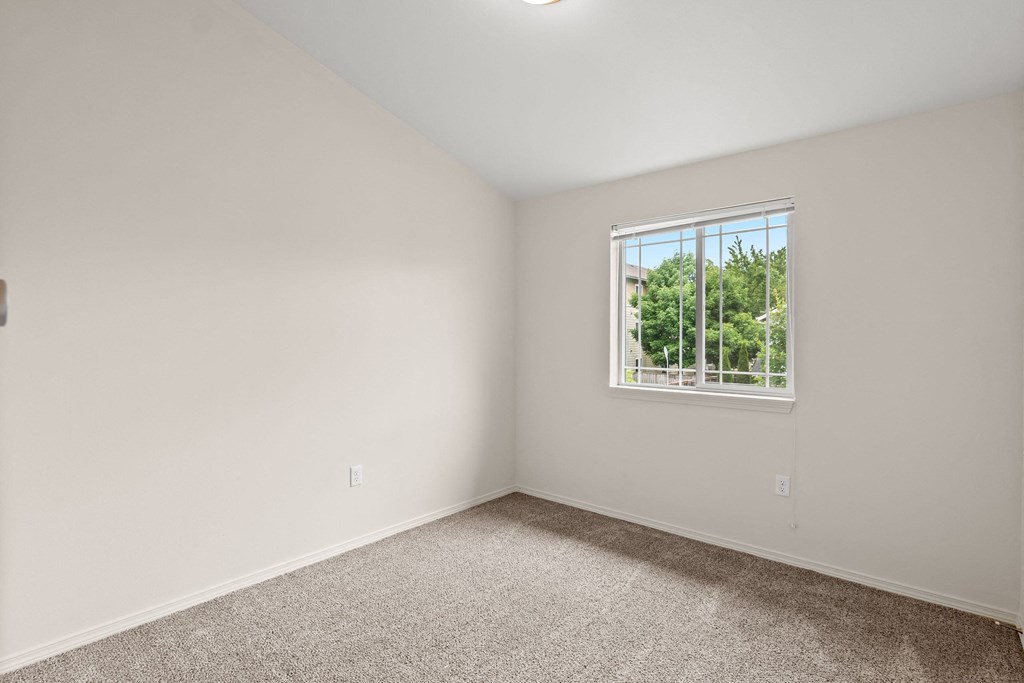 an empty room with carpet and a window at Trillium Apartments, Springfield, OR