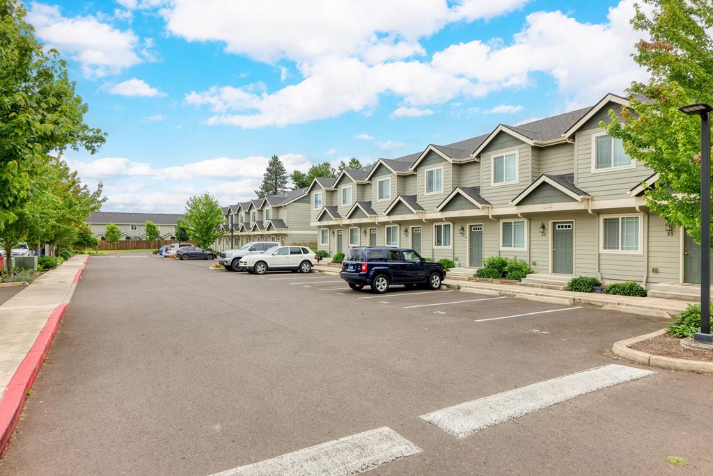 a parking lot with cars parked in front of apartment buildings at Trillium Apartments, Oregon