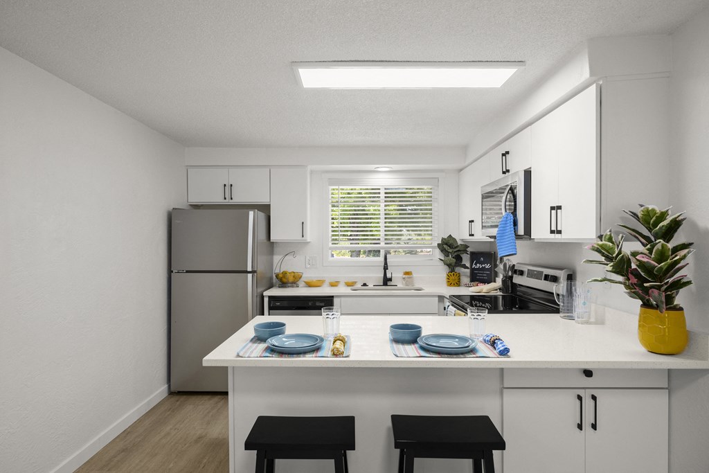 a kitchen with white cabinets and a white island with two black stools in front of it at Chalet, Springfield, OR, 97477