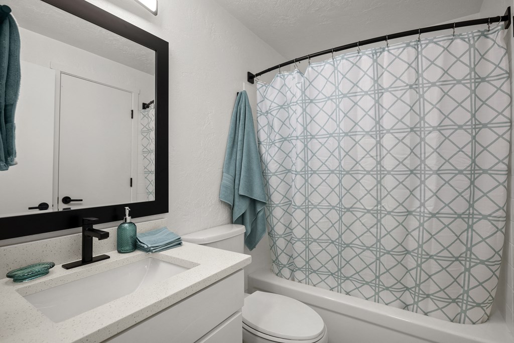 a bathroom with a white sink and toilet next to a bathtub with a shower curtain and at Chalet, Springfield, 97477