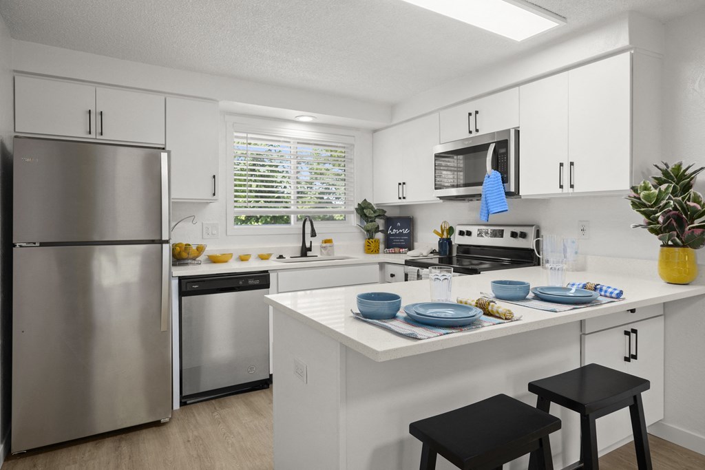 a kitchen with white cabinets and stainless steel appliances at Chalet, Springfield, OR