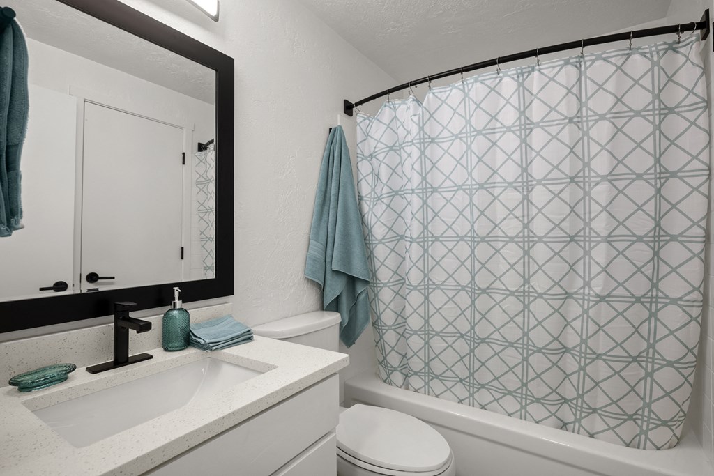 a bathroom with a white sink and toilet next to a bathtub with a shower curtain and at Chalet, Springfield, 97477