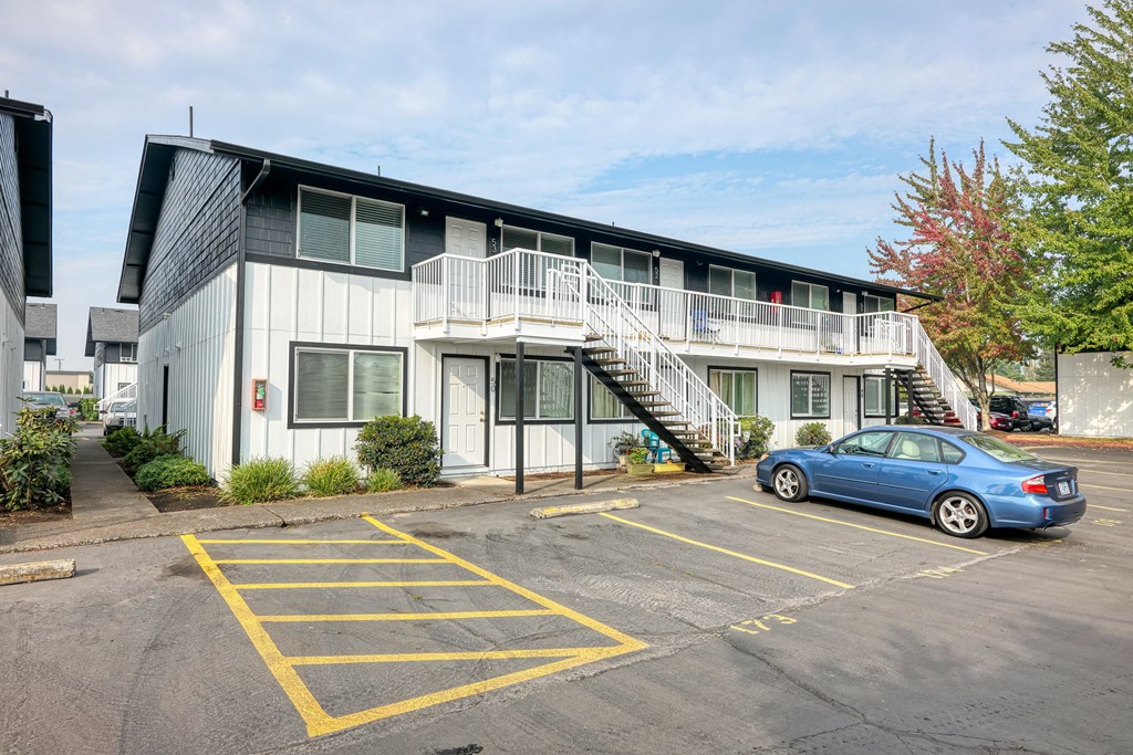 an apartment building with a blue car parked in front of it