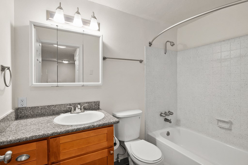 an empty bathroom with a sink toilet and shower