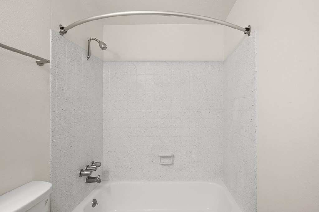 a white bathroom with a white tub and a shower curtain