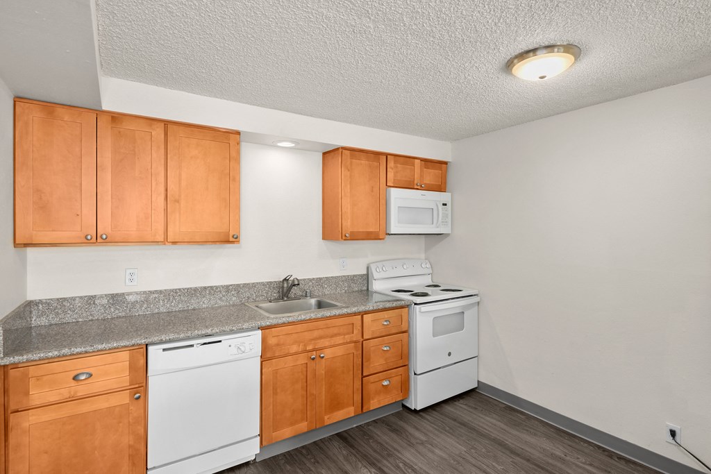 the preserve at ballantyne commons apartment kitchen with white appliances and wood cabinets