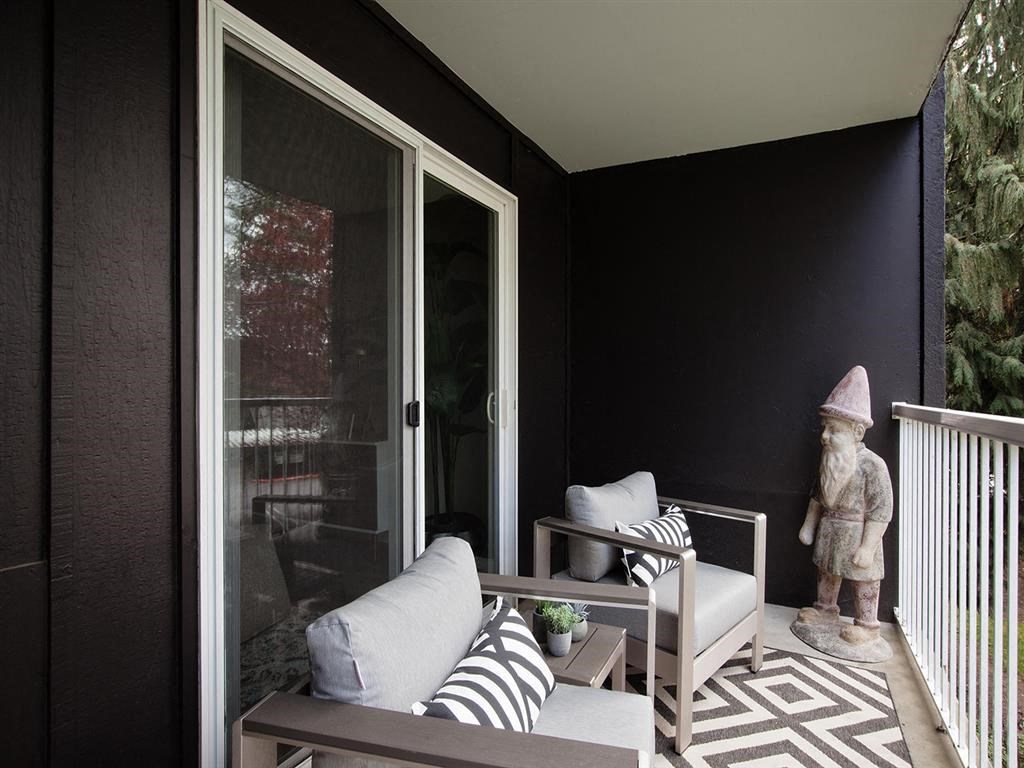 a balcony with a couch and a chair and a statue