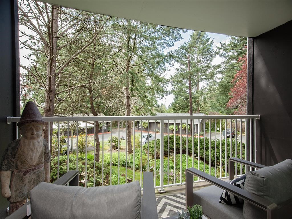 a balcony with a view of a yard and trees