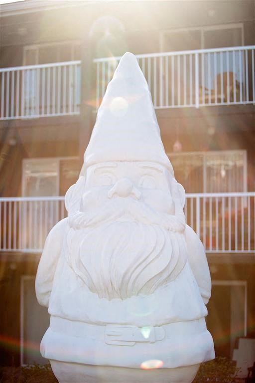 a statue of a gnome with a cone in front of a building
