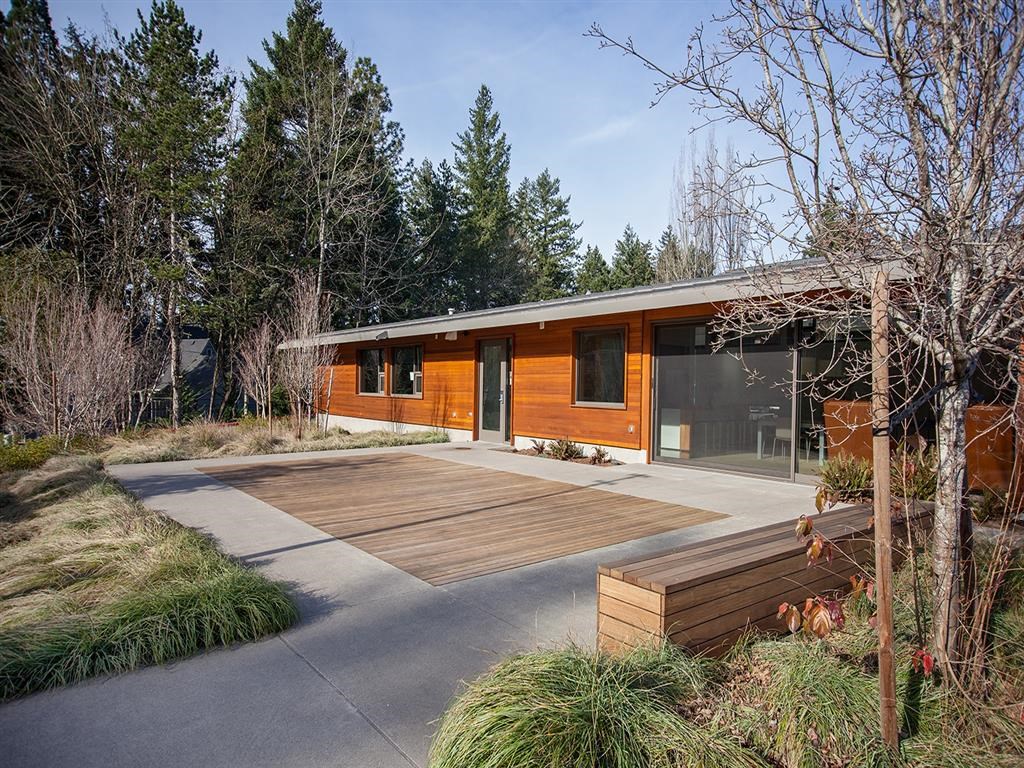 a modern house with a wooden deck in front of it