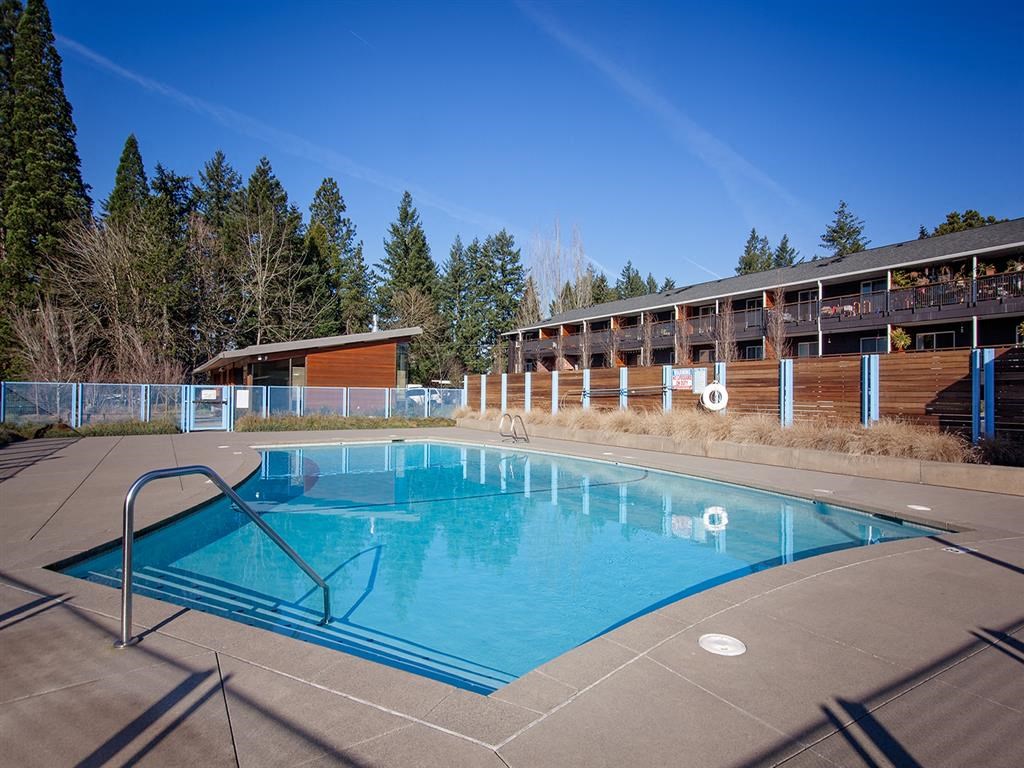 a swimming pool at a resort with a building in the background
