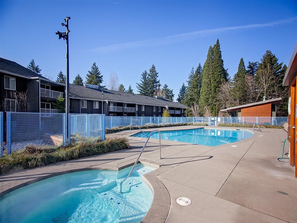 a pool with a fence around it next to a building