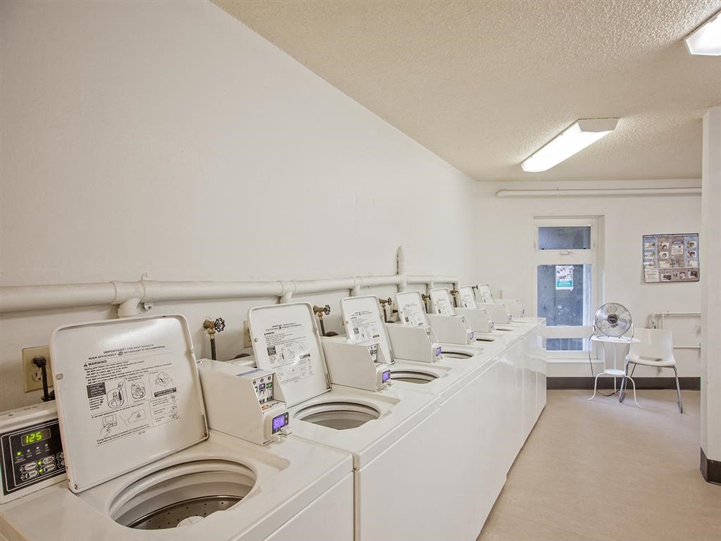 a washer and dryer room with many washing machines