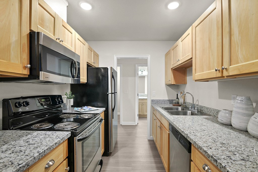 an empty kitchen with granite counter tops and stainless steel appliances