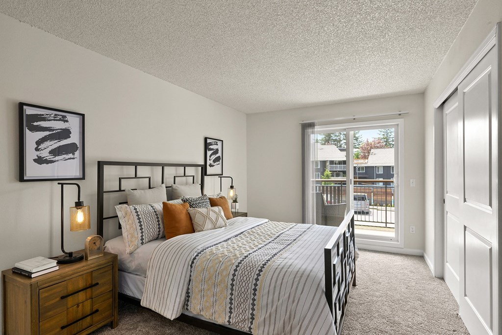 a bedroom with a bed and a door to a balcony