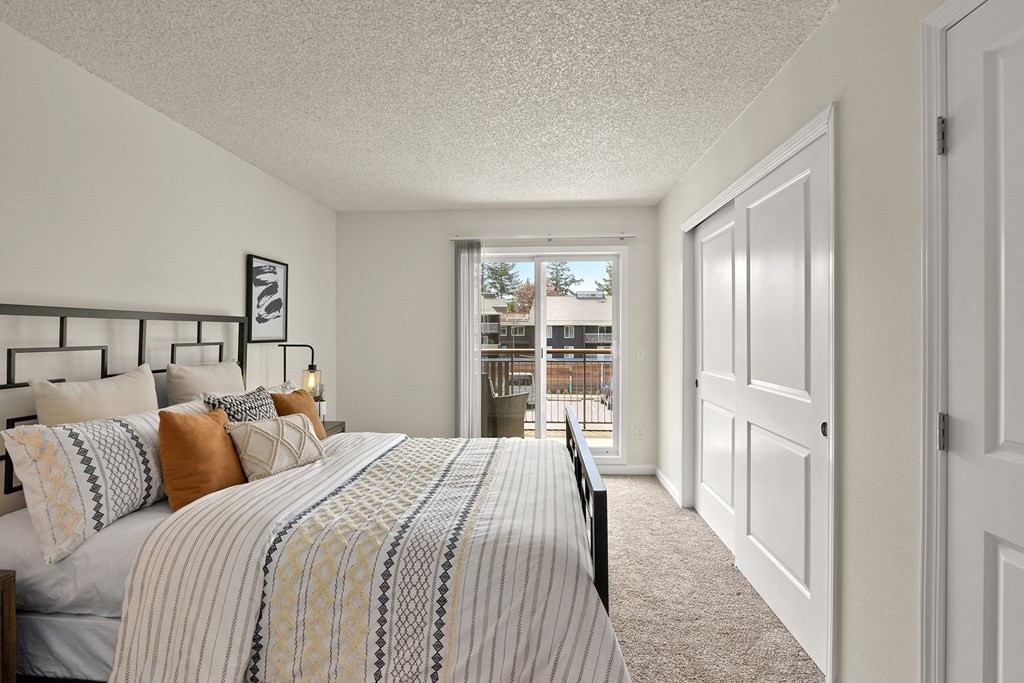 a bedroom with a large bed and a door to a balcony