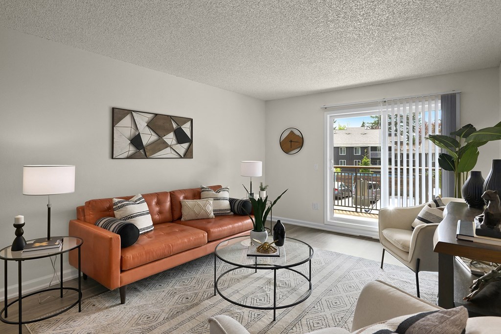 a living room with a brown couch and a sliding glass door