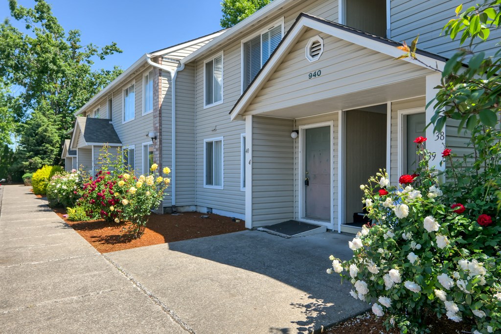 a white house with a sidewalk in front of it
