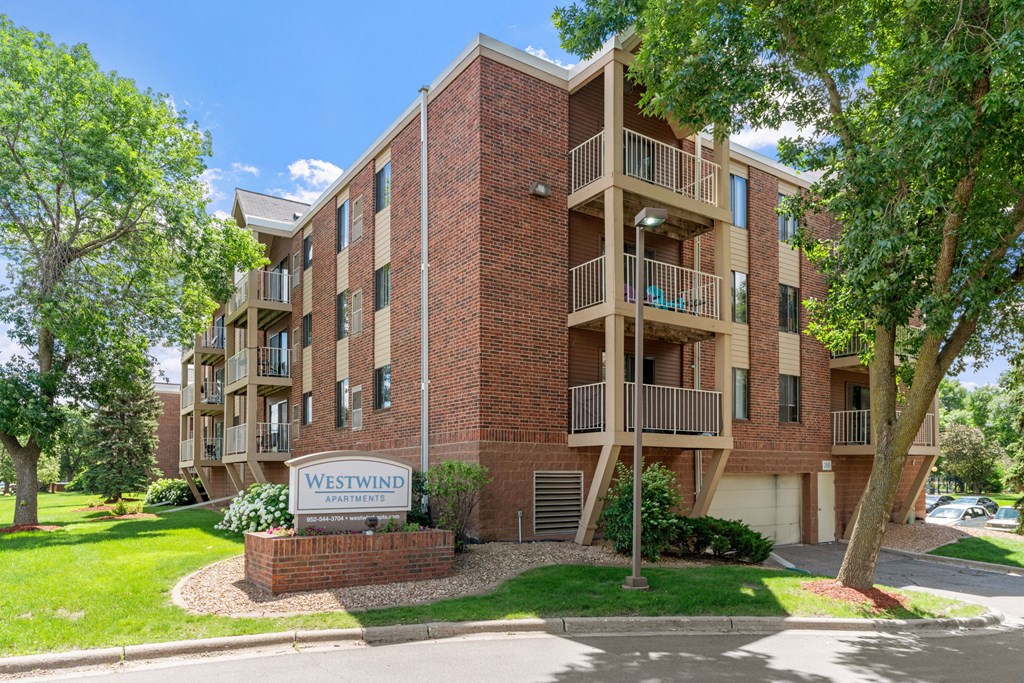 A brick building with the sign Westwind Apartments in front of it.