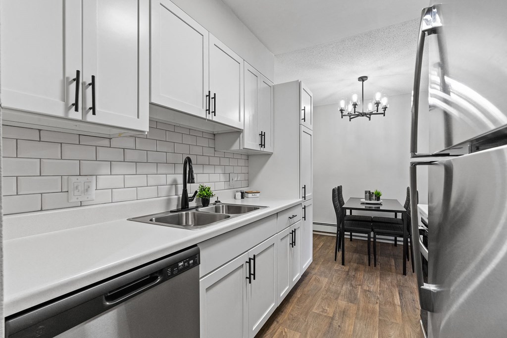 a kitchen with white cabinets and stainless steel appliances and a sink