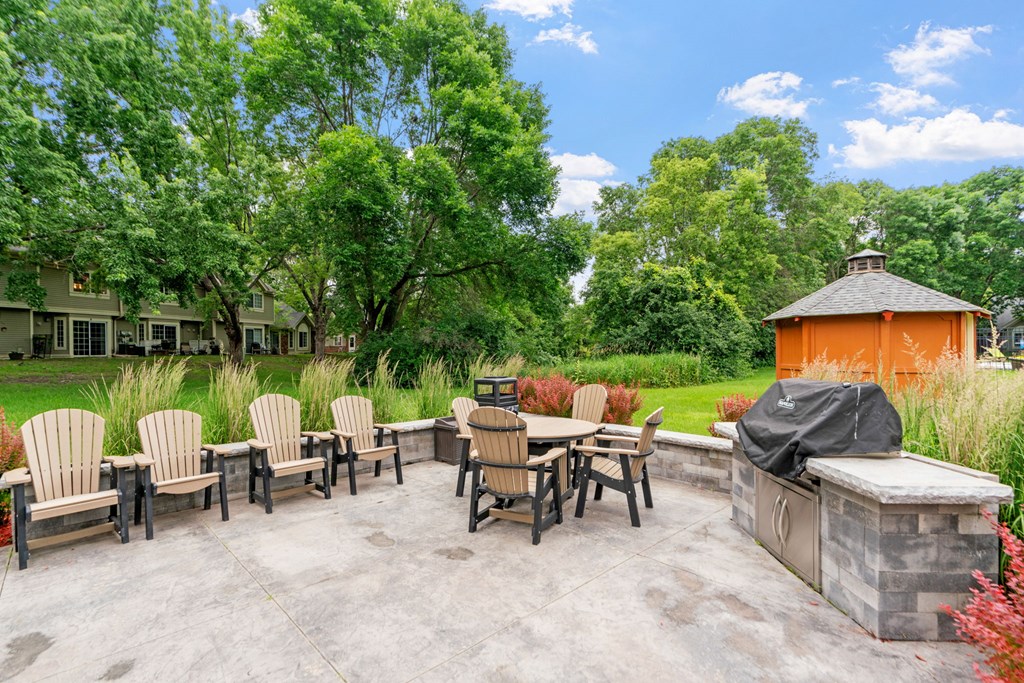 A patio with a table and chairs and a hot tub.
