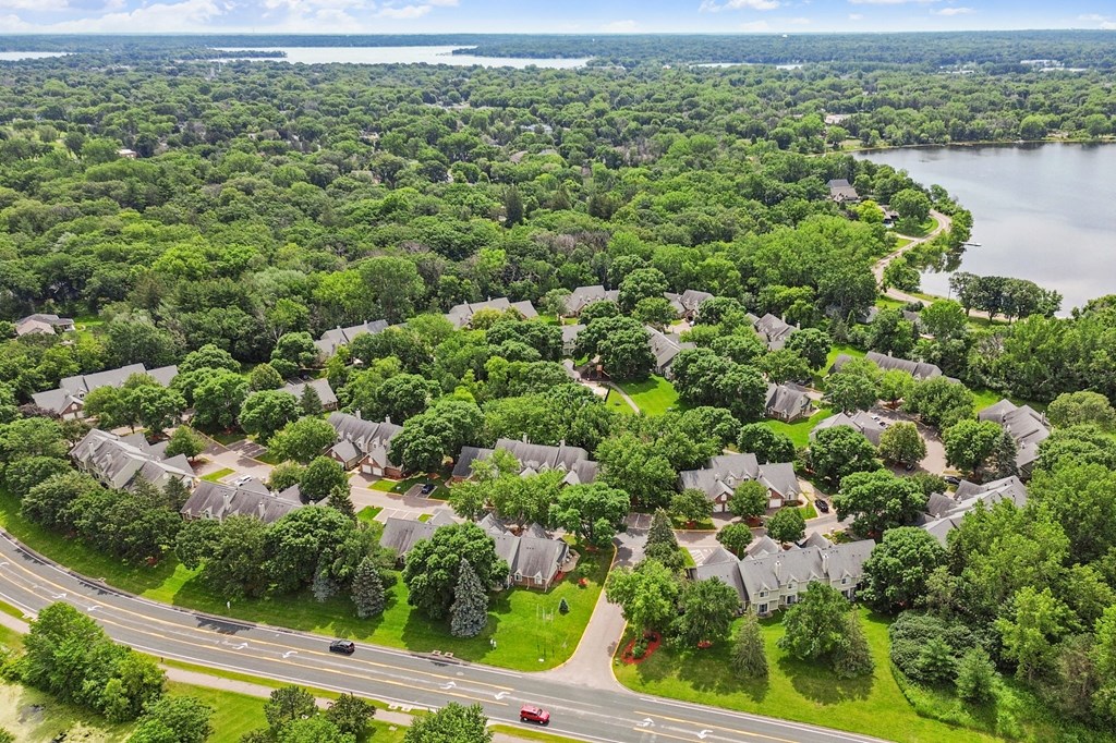 A suburban neighborhood with houses and a lake in the background.
