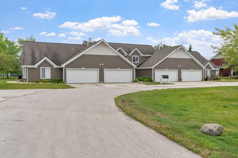 A house with a grey roof and a driveway in front.