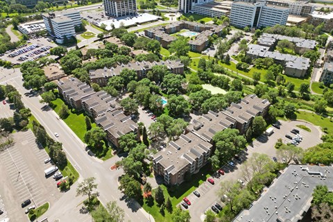 A bird's eye view of a residential area with multiple buildings and cars.
