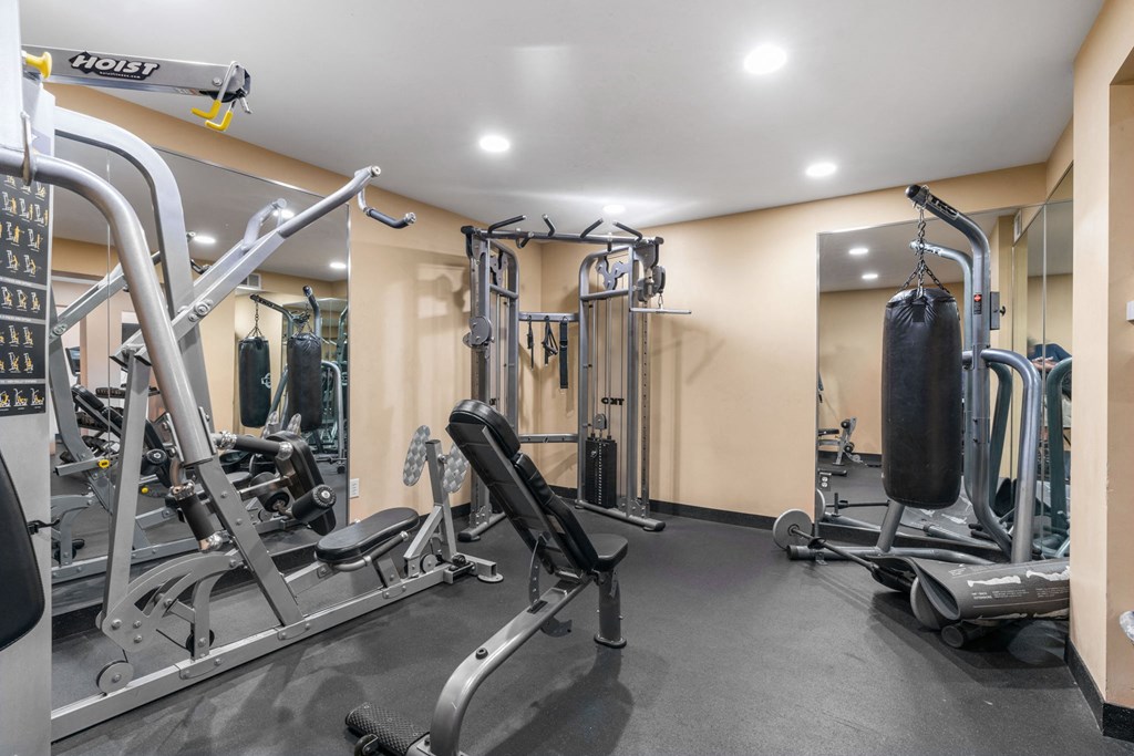 A gym with a variety of equipment including treadmills, weights, and exercise machines.