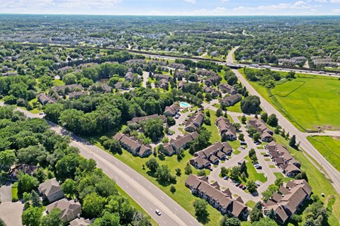 an aerial view of a neighborhood with houses and trees and a highway