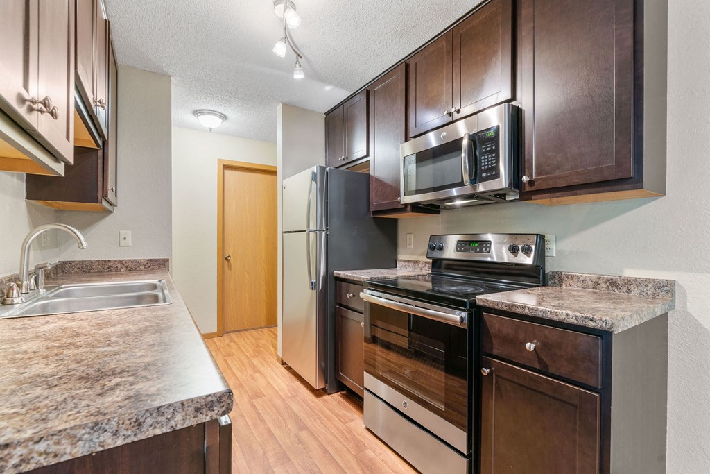 a kitchen with stainless steel appliances and wooden cabinets