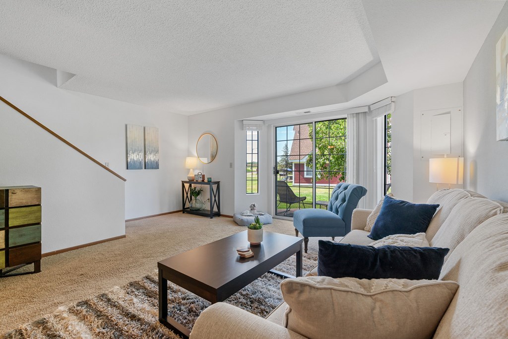 A living room with a couch, chairs, and a coffee table.