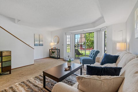 A living room with a couch, chairs, and a coffee table.