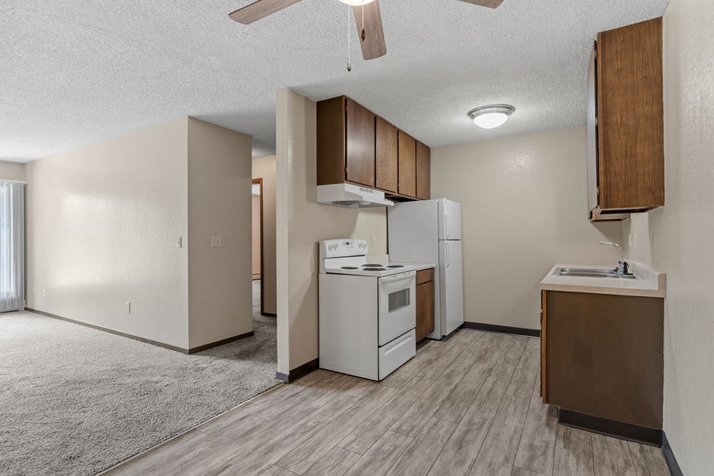 A kitchen area with a white refrigerator, a white oven, and a white dishwasher.