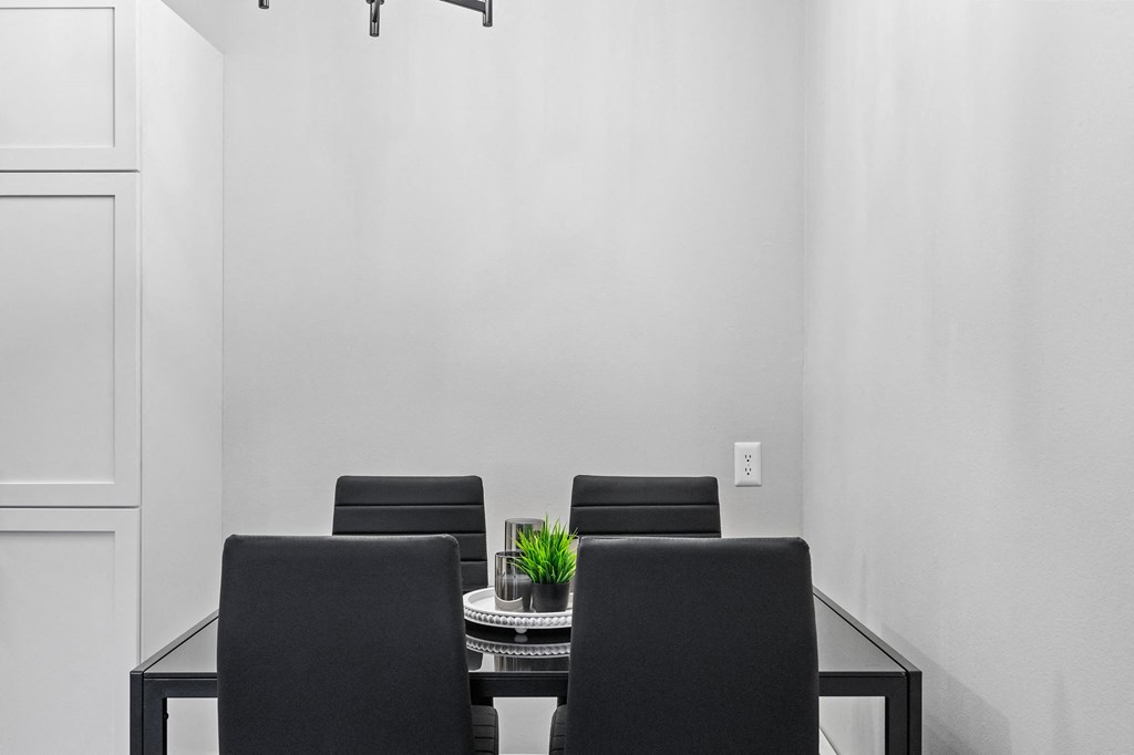 a dining room with a glass table and black chairs