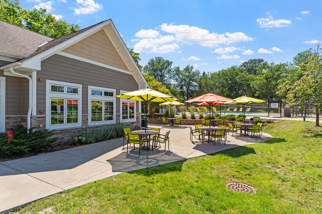 a patio with tables and umbrellas outside of a building