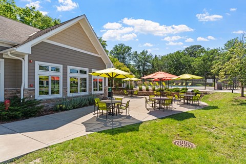 a patio with tables and umbrellas outside of a building